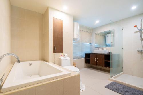 Un baño con bañera, inodoro y lavabo. en Beachside Apt Short Walk to Nai Harn Beach 2-3 BR, en Nai Harn Beach