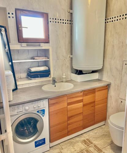 une salle de bain avec une machine à laver et un lavabo dans l'établissement Joumana tourisme, à Gouvernes