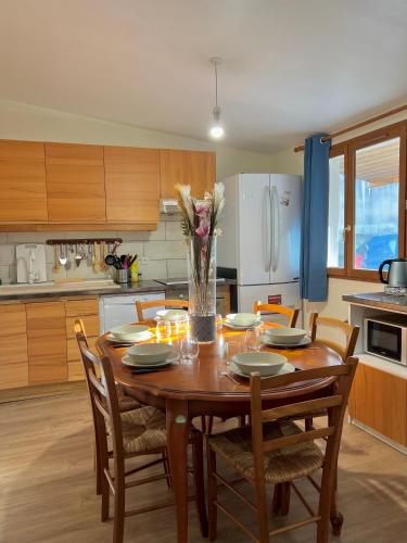une cuisine avec une table en bois et un vase de fleurs dans l'établissement Joumana tourisme, à Gouvernes