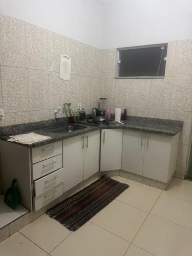 a kitchen with a sink and a counter top at Hospedaria Mantovani in Tatuí