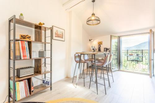 une pièce avec une table, des chaises et une étagère dans l'établissement Vermeille - Appt 2p avec jolie vue, à Céret