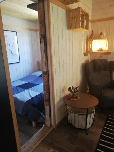 une petite pièce avec un lit et une table dans l'établissement Charmante cabane à la ferme, à 15 min de Moissac, à Moissac