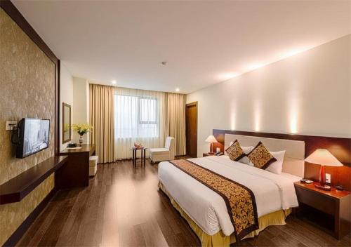 a hotel room with a large bed and a television at Muong Thanh Grand Ha Tinh Hotel in Kỳ Anh