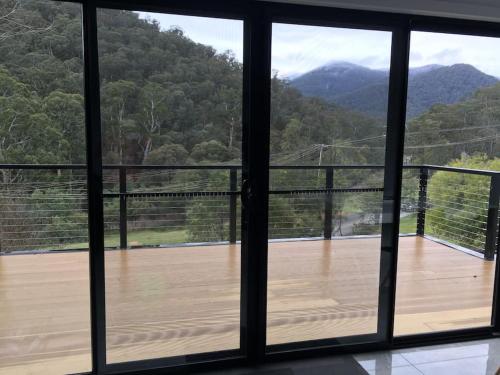 a view from a window of a deck with mountains at Watsons in Merrijig