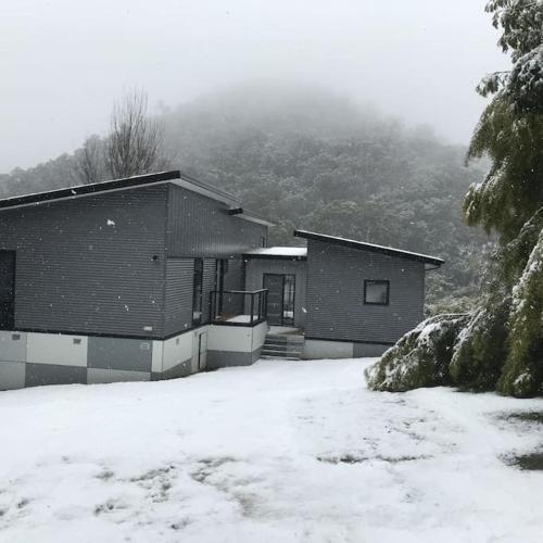 a house with snow on the ground in front of it at Watsons in Merrijig