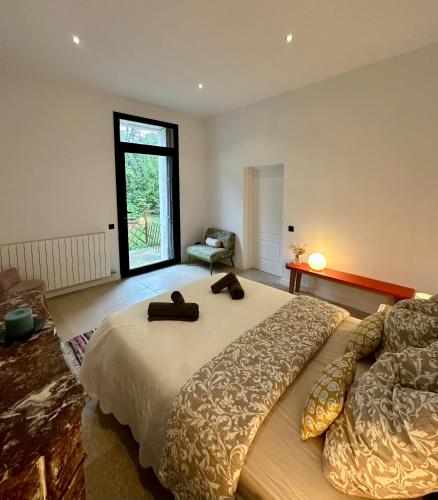 une chambre avec un grand lit et une chaise dans l'établissement Maison Spacieuse au Bord du Lez, 5pers, Calme, Wi-Fi, Jardin Privé, Parking Gratuit, à Montpellier
