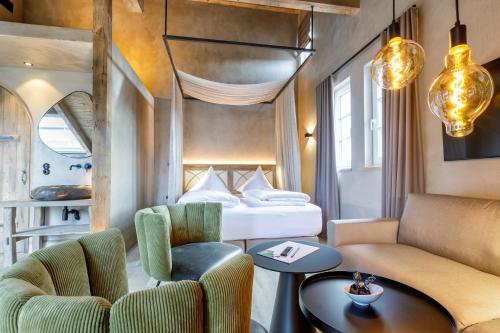 a hotel room with a bed and a table and chairs at Hotel Arthus in Aulendorf