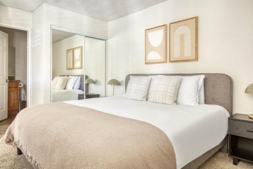 a bedroom with a large white bed and a mirror at N Hollywood 1BR w Gym Pool nr shops LAX-515 in Los Angeles