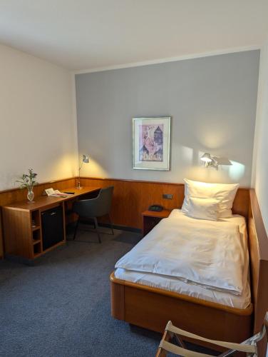 a hotel room with a bed and a desk at Historik Hotel Garni Christinenhof in Hameln