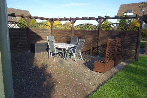a patio with a table and chairs under a pergola at Ferienwohnung "Meißner" in Rechlin