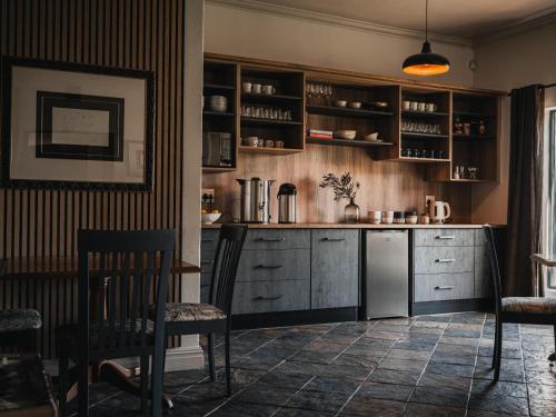a kitchen with wooden cabinets and a table and chairs at Cape Panorama Lodge in Panorama