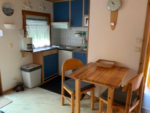 a kitchen with blue cabinets and a wooden table at Ferienhaus "Gluch" in Rechlin