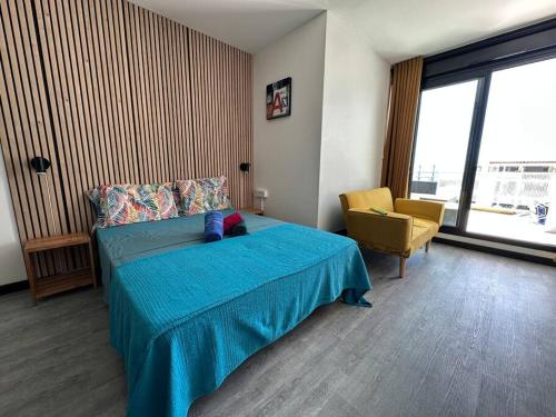 圣丹尼斯StuDio 75 pour 2 personnes avec terrasse - vue mer的一间卧室配有蓝色的床和黄色的椅子