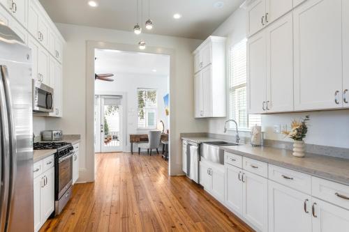 a kitchen with white cabinets and a hardwood floor at Spacious 3BR Garden District Home w Pool & Balcony in New Orleans