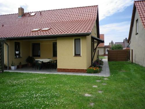 a yellow house with a table in the yard at Ferienwohnung "Ganz 1" in Vipperow