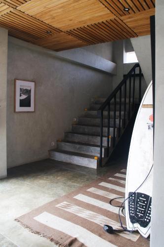 a room with a staircase and a surfboard in it at Surf Motel in Canggu