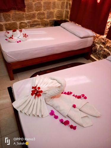 a room with two beds and a towel on a table at palm shadow resort in Tunis