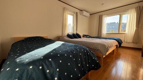 a bedroom with two beds and a window at SecondHouse Otaru Garden in Otaru