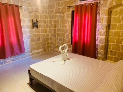 a bed in a room with red curtains at palm shadow resort in Tunis