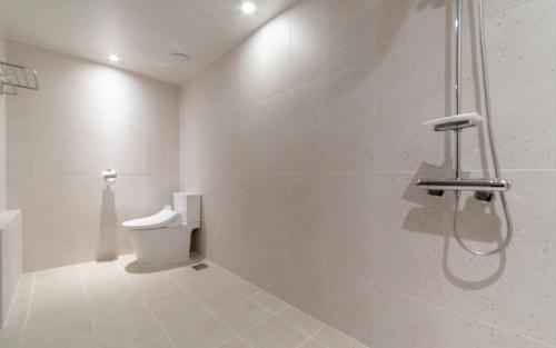 a white bathroom with a shower and a toilet at Aank Hotel Incheon Bupyeong in Incheon