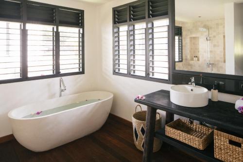 a bathroom with a large tub and a sink at Villa Puri Greenlot Cemagi in Canggu