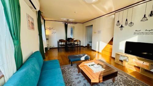 a living room with a blue couch and a table at SecondHouse Otaru Garden in Otaru