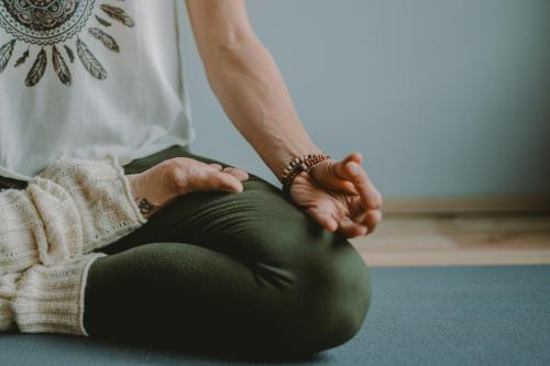 a woman sitting on the floor with her hands on a yoga ball at Hotel Mühlenerhof in Campo Tures