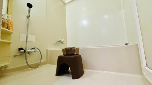 a bathroom with a shower with a trash can at SecondHouse Otaru Garden in Otaru