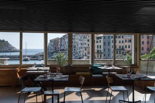a restaurant with tables and chairs and a view of the ocean at Grand Hotel Portovenere in Portovenere