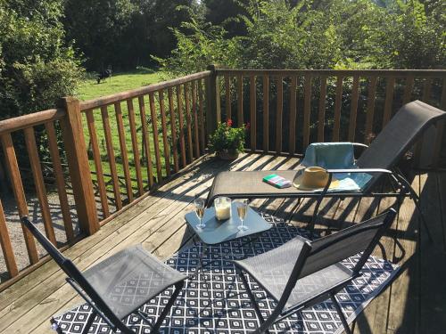 un patio avec deux chaises et une table sur une terrasse dans l'établissement Le Cottage Picard, à Yvrench