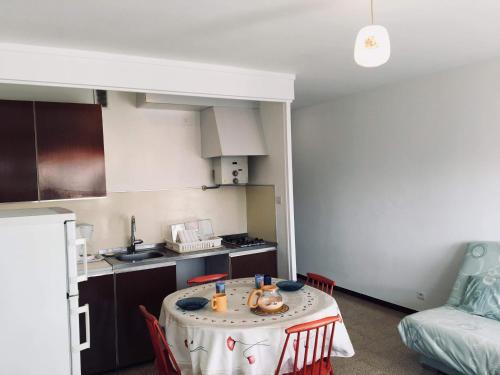 - une petite cuisine avec une table au milieu d'une pièce dans l'établissement Grand studio avec terrasse proche du port de Saint Cyprien -3RM168, à Saint Cyprien Plage