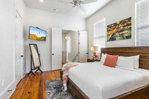 a bedroom with a bed and a painting on the wall at Fabulous Cottages with City Views in New Orleans