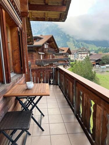 a balcony with a wooden table and chairs on a building at Charming apartment in Kandersteg in Kandersteg