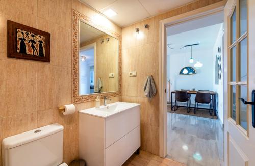 ein Badezimmer mit Toilette, Waschbecken und Spiegel in der Unterkunft Luci by The Sea in La Herradura