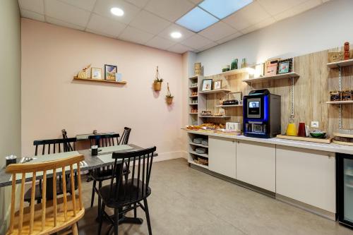 a kitchen with a table and chairs and a microwave at Grand Hôtel Lille in Lille