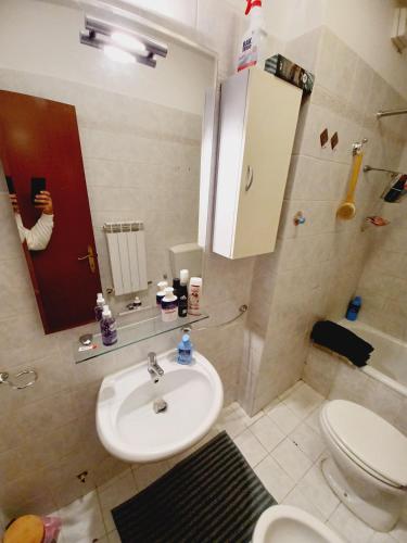 a bathroom with a sink and a toilet and a mirror at Casa di Minù in Empoli