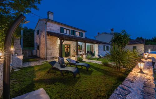un jardín con bancos frente a un edificio en Villa Ana Rita for 6 people - beautiful rustical villa with heated pool & jacuzzi in Central Istria, en Kanfanar