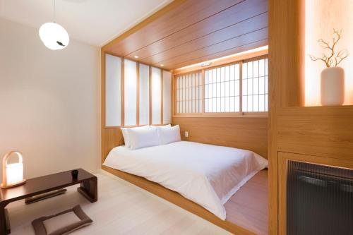 a small room with a bed and a window at Hotel Yusurim in Changwon