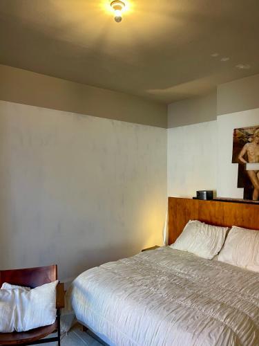 a bedroom with a bed and a chair in it at Huis Hector Mechiels ROOM in Sint-Niklaas