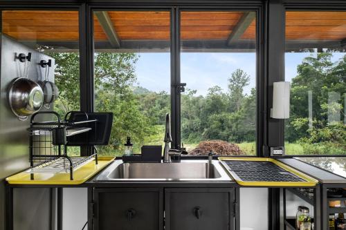 a kitchen with a sink and a large window at Casa Algarrobo relaxing farm stay in Puerto Rico in Cerro Gordo