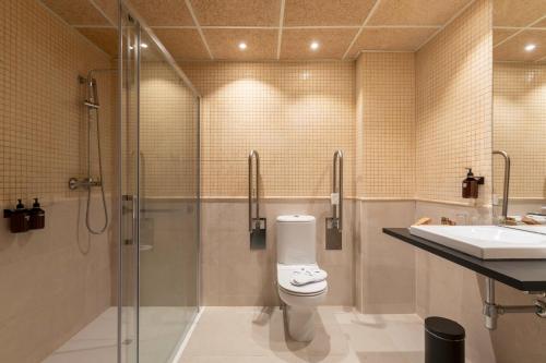 a bathroom with a shower and a toilet and a sink at Acta Sant Just in Sant Just Desvern