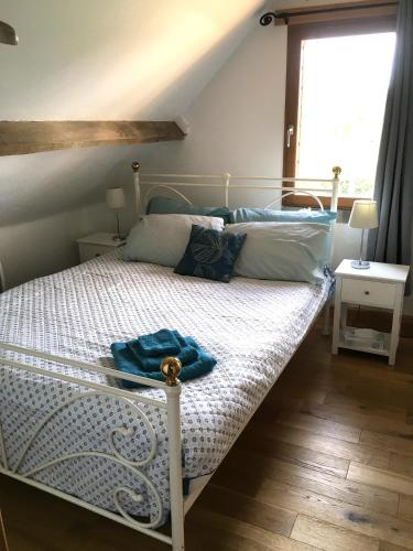 - une chambre avec un lit doté d'un couvre-lit blanc et d'une fenêtre dans l'établissement Le Cottage Picard, à Yvrench