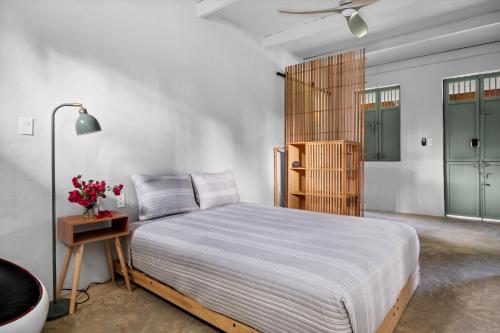 a bedroom with a bed and a table with flowers at Casa Algarrobo relaxing farm stay in Puerto Rico in Cerro Gordo