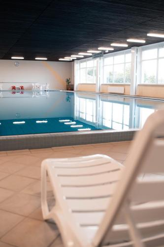 a swimming pool with a bench in a room at Terrassenhaus Waldblick 637 in Hohegeiß