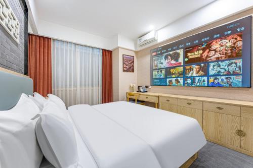 a hotel room with a large bed and a flat screen tv at 广州柠下酒店科韵路琶洲会展中心店 in Guangzhou