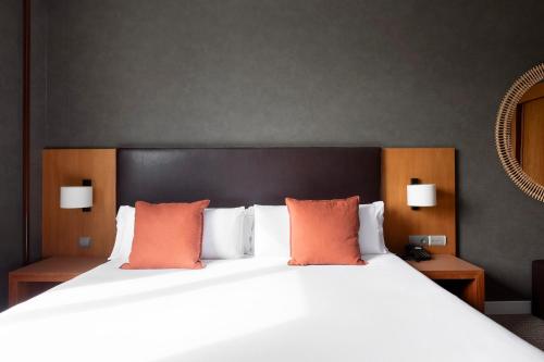 a bedroom with a large white bed with orange pillows at Acta Sant Just in Sant Just Desvern