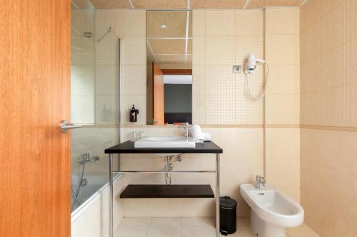 a bathroom with a sink and a tub and a toilet at Acta Sant Just in Sant Just Desvern