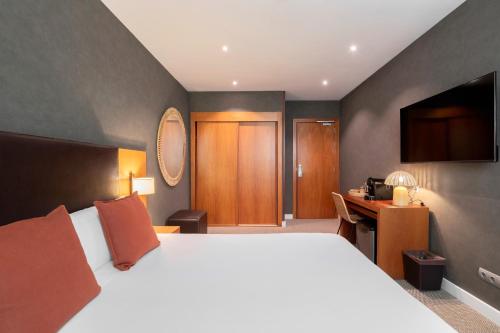 a hotel room with a large bed and a desk at Acta Sant Just in Sant Just Desvern