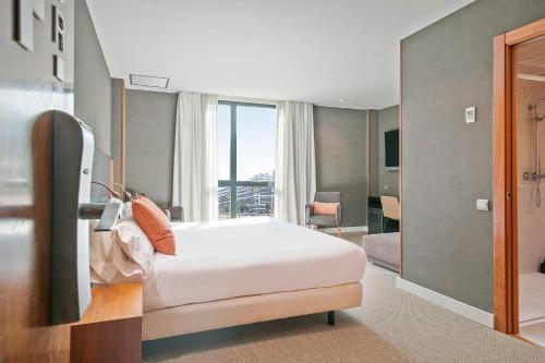 a hotel room with a bed and a large window at Acta Sant Just in Sant Just Desvern