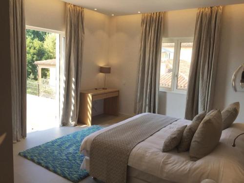 une chambre avec un lit et une grande fenêtre dans l'établissement Hôtel Golf & Spa Château de la Bégude The Originals Collection, à Valbonne